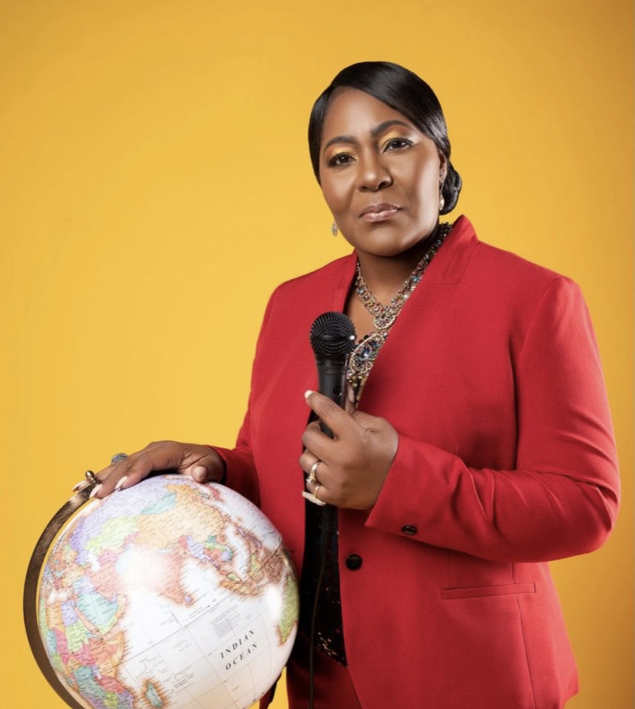 A powerful photo of Dr. B walking with a globe and microphone in hand